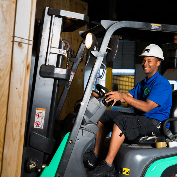 Forklift driver moving storage pods at The Green Truck Moving & Storage Company